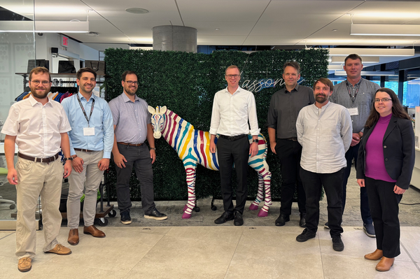 Gruppenfoto mit Workshopteilnehmerinnen im Hintergrund eine Blätterwand, ein buntes PonyModell und ein großer Raum